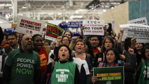 People protesting for climate debt reparations